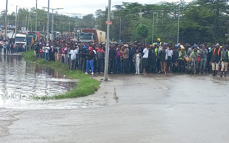 Onlookers at River Athi-river after it burst its banks this morning after heavy downpour in the upper regions of Kitengela reserve and Sholinke. PHOTO/Christine Musa